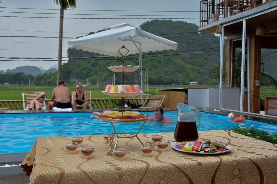 Ninh Binh Daily: Hoa Lu, Mua Cave, Tam Coc, Bike & Swimming - Swimming, sunset fruit, and the pool party cooldown